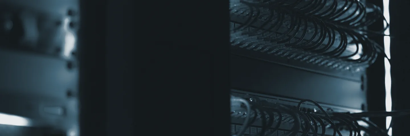 An equipment cabinet in a dark room, with status lights running down its front.